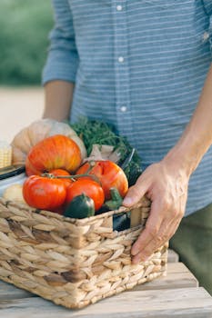 Person Holding Brown Woven Basket With Red Tomato